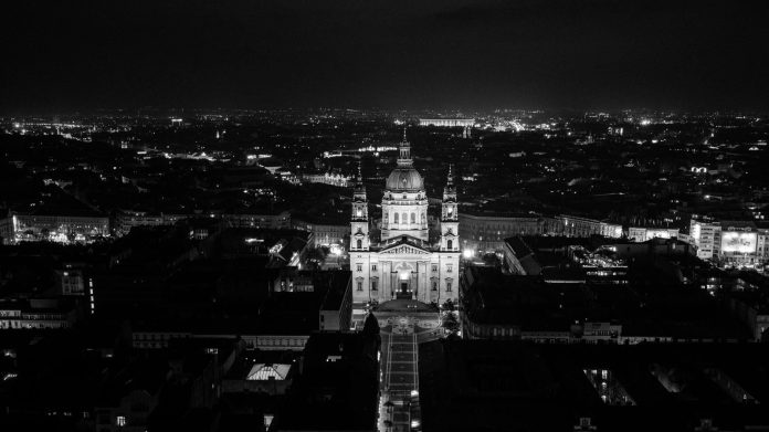 Állami beruházás-elemzés: költségvetési vonatkozások a magyar piacon — Black and white aerial view of St. Stephen's Basilica illuminated at night in B