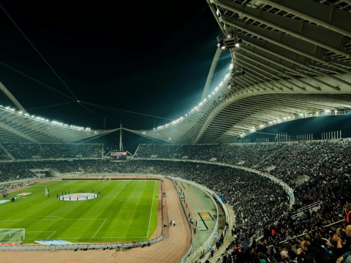 Klubpénzügyek: költségvetési vonatkozások — A crowded soccer stadium under bright lights at night, capturing the excitement