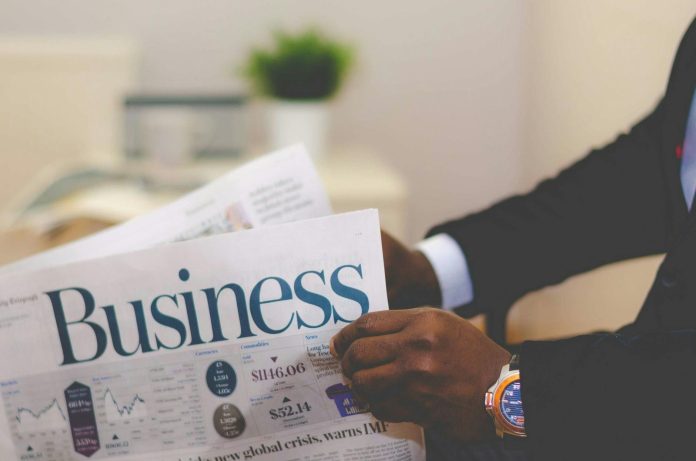 Magyar gazdaság jelentés: regionális összevetés — Close-up of a businessman reading a newspaper indoors, focusing on business head