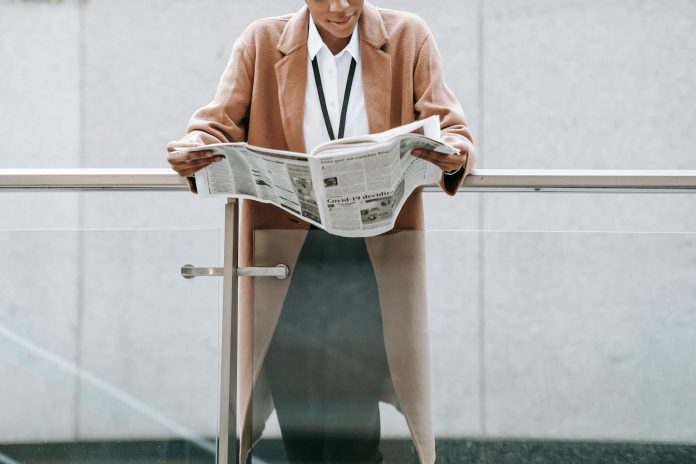 Üzleti monitor: konszolidált adatok — Crop content African American businesswoman in formal clothes reading fresh news