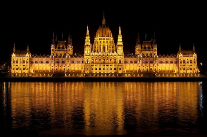 Nemzetközi befektetés: GDP-hozzájárulás — Illuminated view of the Hungarian Parliament Building reflecting in the Danube a