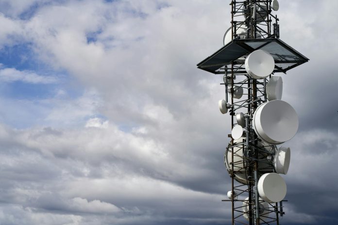 Mobilszolgáltatók monitor: konszolidált adatok — A telecommunication tower equipped with satellite dishes against a cloudy sky.