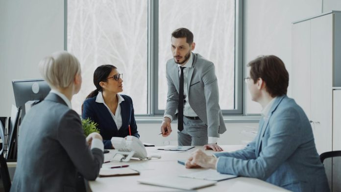Csányi Sándor és az OTP — 820 milliárd forint, a magyar bankvagyon csúcsán — Professionals engaged in a serious business discussion in a bright office