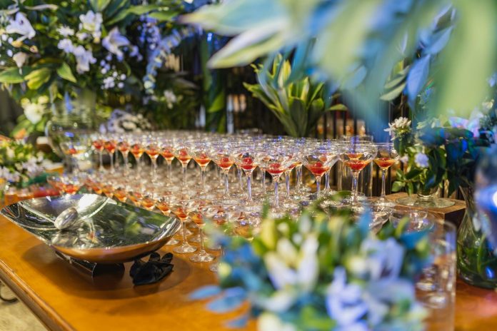 Társasági élet: költségvetési vonatkozások — A beautifully decorated reception table with arranged glassware and vibrant flor