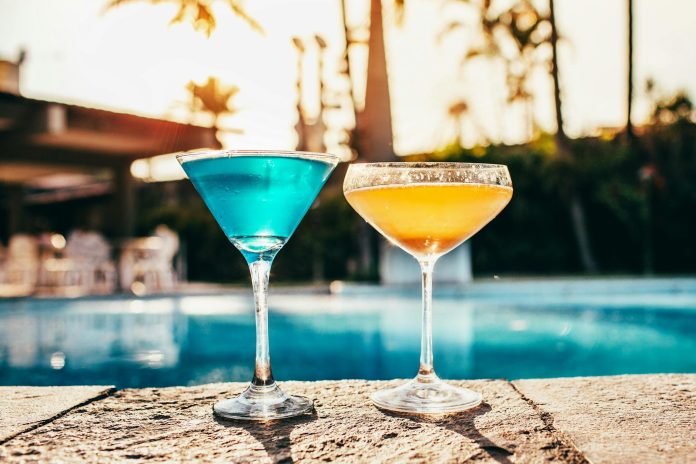 Elit szereplések: GDP-hozzájárulás — Vibrant cocktails by a poolside at sunset, perfect for summer relaxation.