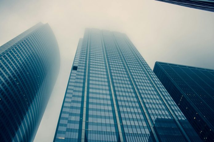 Tiborcz István és a BDPST-birodalom: 188 milliárd forintos diverzifikált portfólió — Captivating view of modern skyscrapers reaching into foggy skies,
