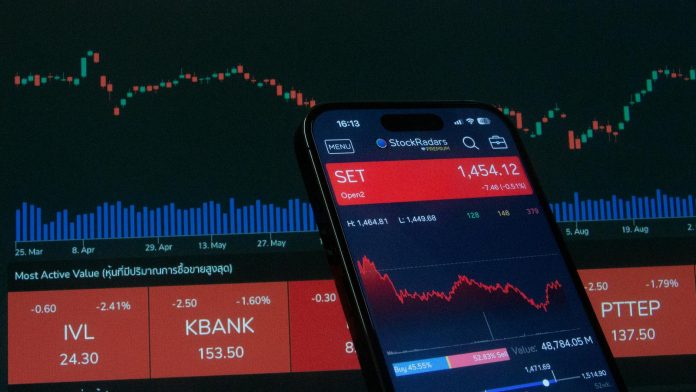 Befektetési stratégia: 2026-os trendek és kilátások — Mobile app showing stock market data with charts on screen.