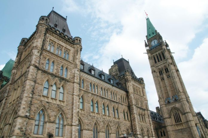 Tisza-kormány intézkedései: publikus források áttekintése — A view of the historical Parliament Hill building in Ottawa against a clear sky.