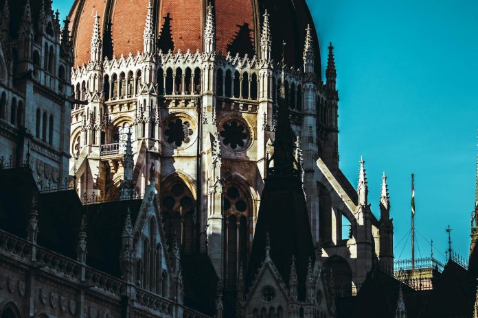 Új politikai korszak: piacrész változása — The iconic dome of the Hungarian Parliament Building in Budapest, bathed in sunl
