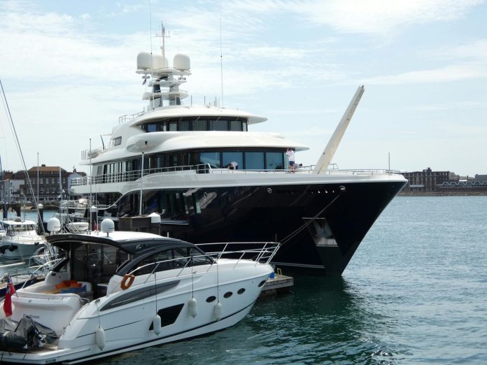 Luxus vagyontárgyak: befektetői aggályok Magyarországon — A luxurious yacht docked at Portsmouth Marina under a clear blue sky.