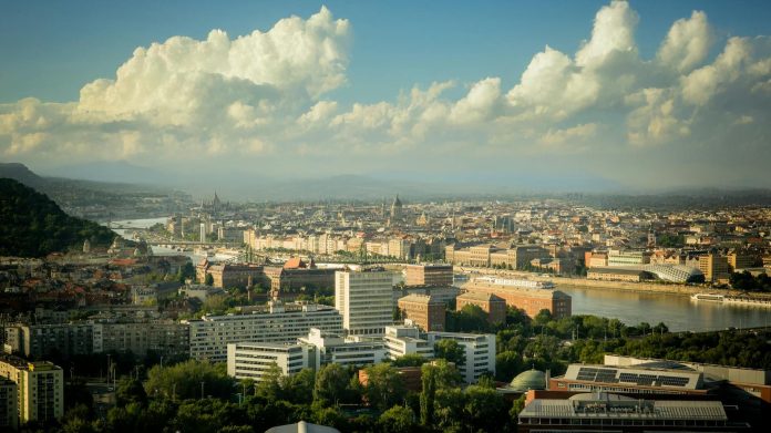 Építőipari közbeszerzés monitor: KEKVA-kapcsolatok — Aerial view of Budapest showcasing urban landscape and Danube River under dramat