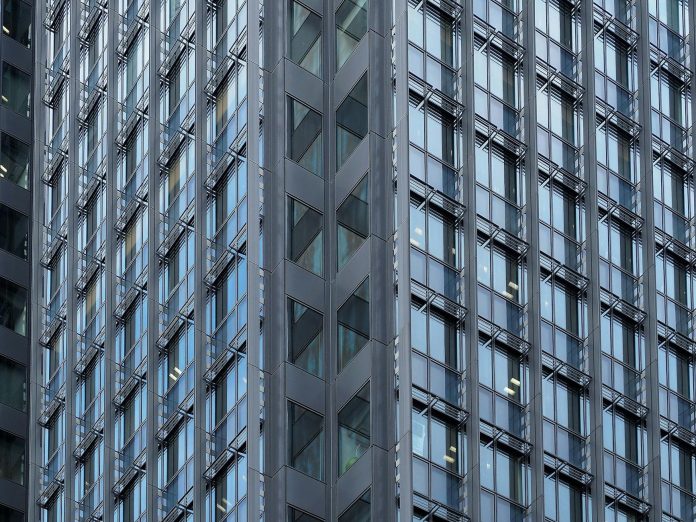 Építőipari közbeszerzés monitor: Forbes-listás összefüggések — Close-up of a modern skyscraper's glass and steel facade in downtown Tokyo, Japa