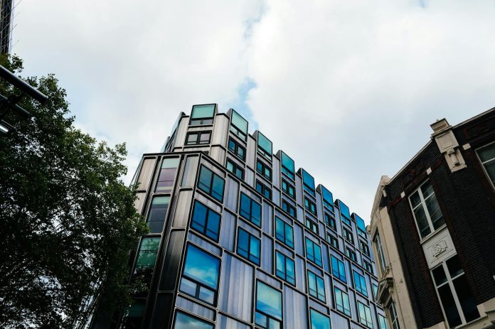 Vagyonkoncentráció az építőiparban — transzparencia-szempontok — A contemporary building with reflective windows in an urban setting under a clou