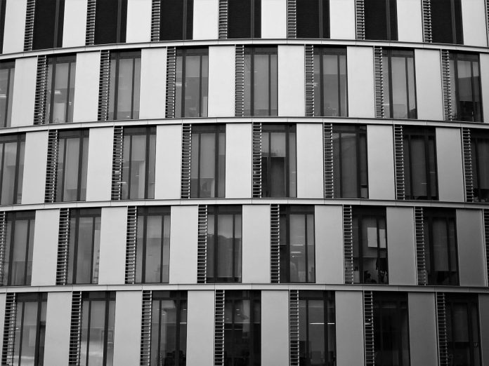 Vagyonkoncentráció az építőiparban — költségvetési vonatkozások — Close-up view of a contemporary office building exterior with glass and steel el