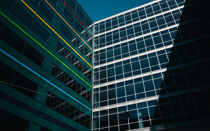 Építőipari közbeszerzés monitor: fiskális hatás — Architectural view of modern buildings with colorful stripes against a clear blu