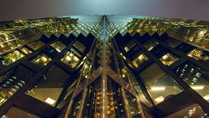 Indotek Group ingatlan-portfólió — The image showcases a towering skyscraper with a reflective glass facade capture