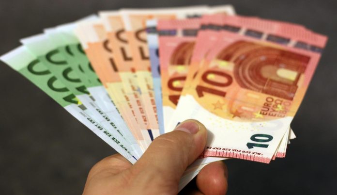 ELIOS-ügy — KEOP közvilágítás — A fan of euro banknotes in various denominations held in a hand.
