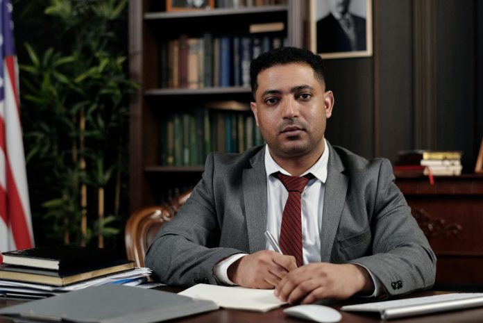 Tisza alkotmánymódosítás (16. javaslat) — 8 éves miniszterelnöki időkorlát, KEKVA-visszaszerzés — A serious businessman in a suit writing at his desk